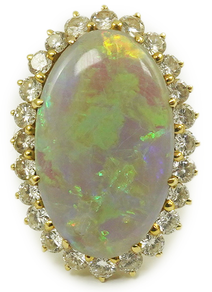 An 18ct gold, white opal and diamond set oval cluster dress ring, the cabochon opal measuring approximately 22mm by 14.5mm, with a depth of 5mm, and bordered by round brilliant cut diamonds, size L, gross weight 6.8 gram